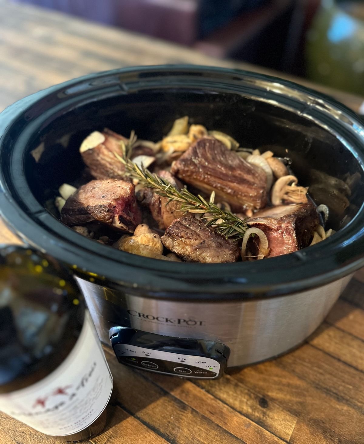Slow cooker full of keto beef short ribs with rosemary