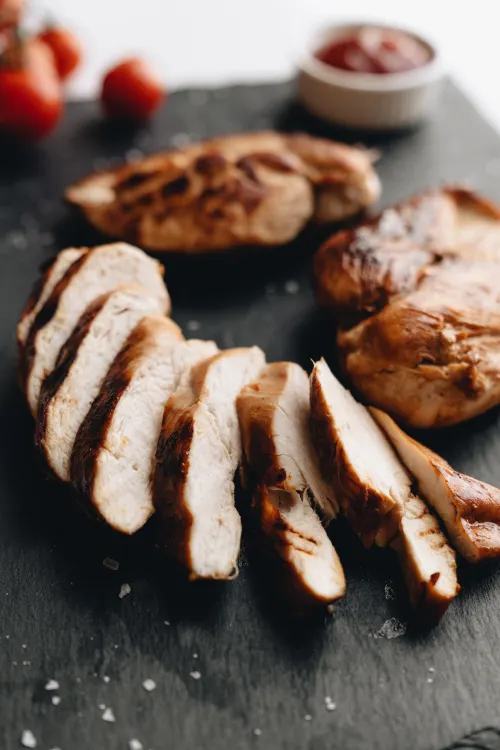 Grilled chicken breast with char marks on a grill