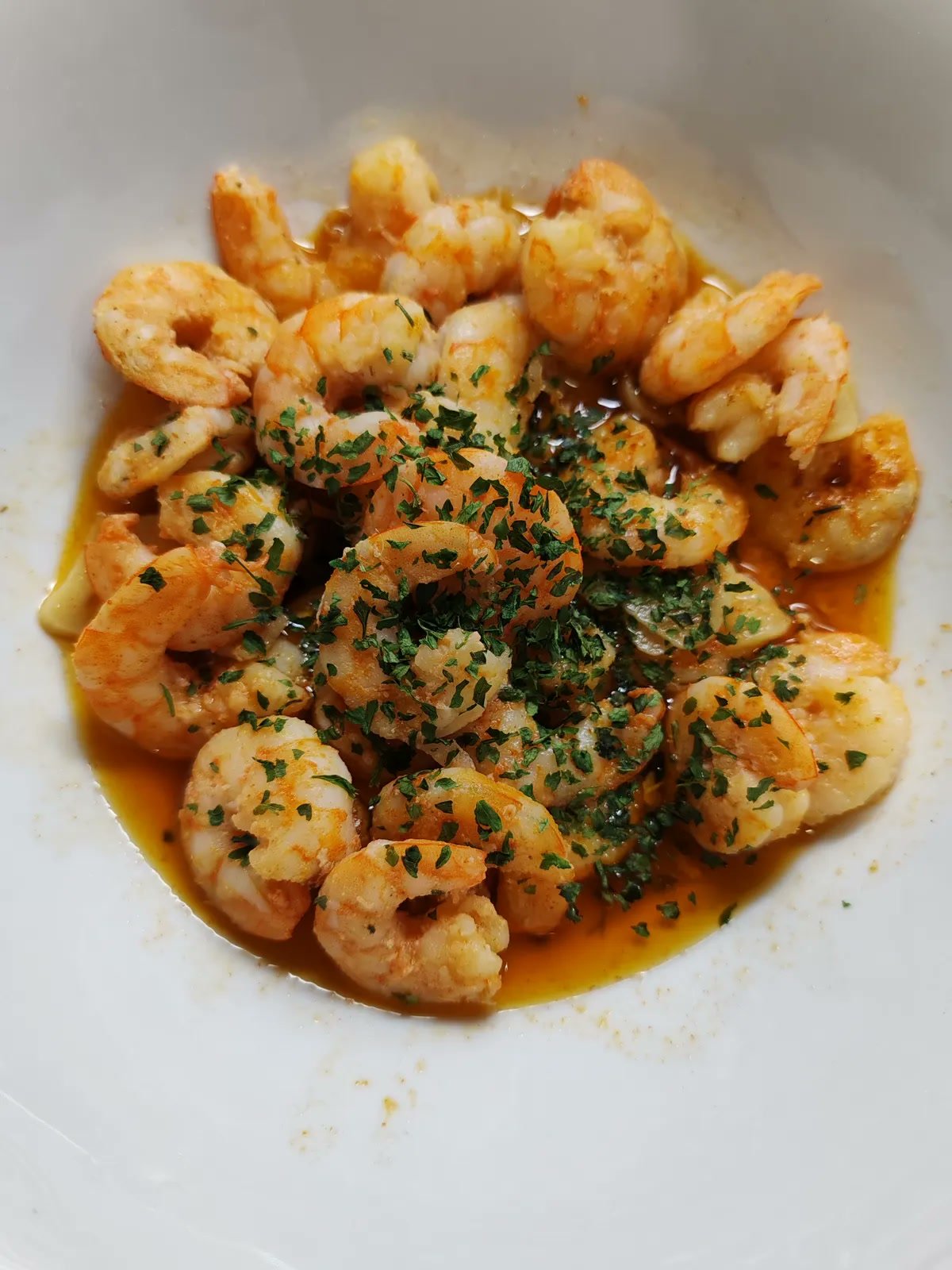 Garlic butter shrimp sizzling in a pan