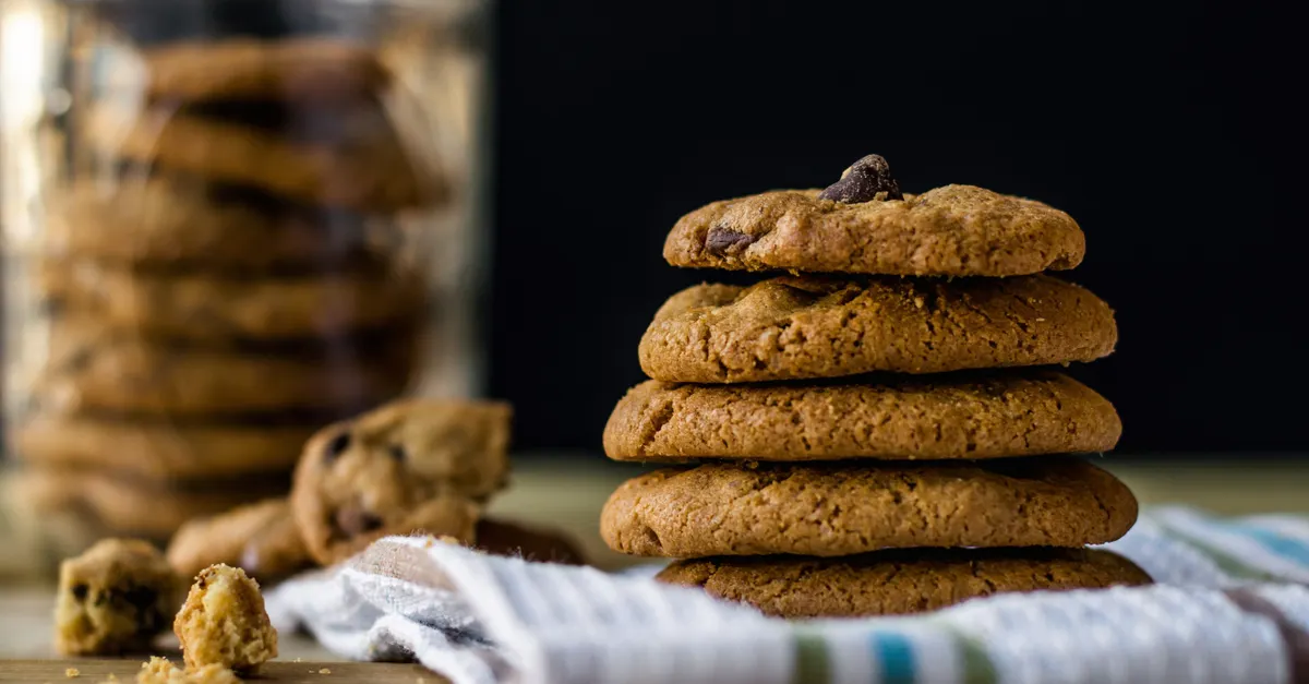 Pile of golden chocolate chip cookies stacked on a plate